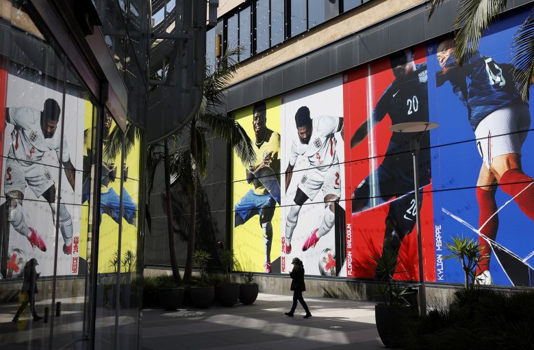 A pedestrian walks by a display of international soccer player photos outside of a Nike store on June 10 in Santa Monica, California.