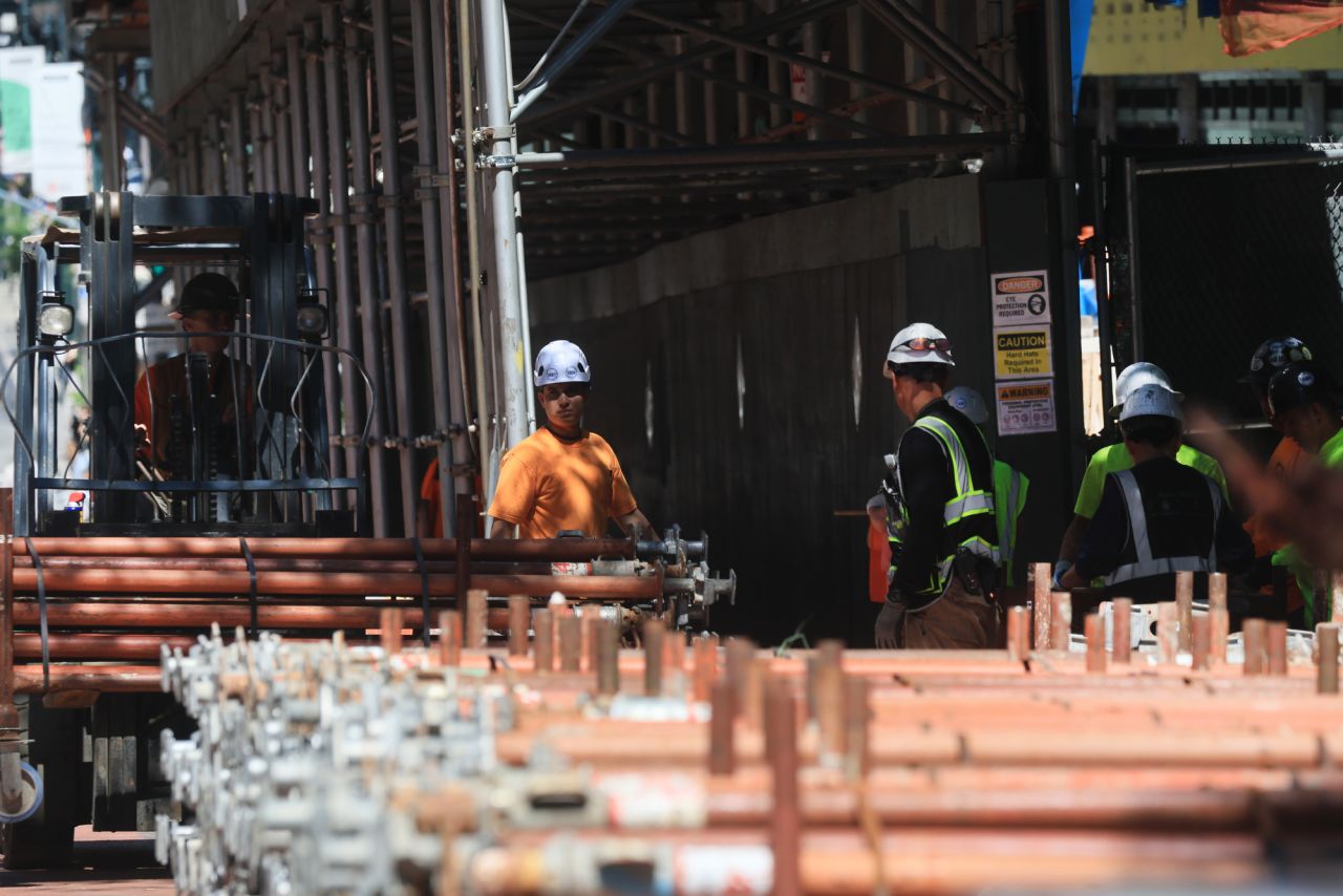 Workers gather outside the former Pfizer headquarters building on Wednesday in New York City.
