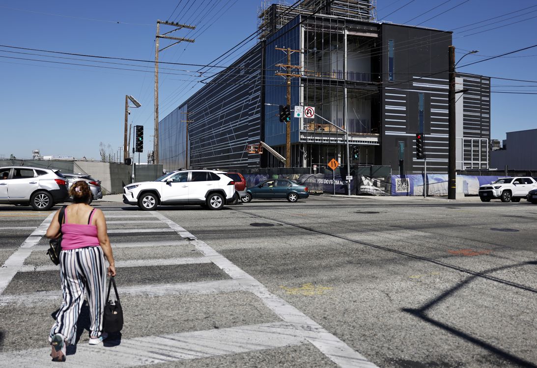 A pedestrian walks near a 49.5 megawatt three-level data center under construction on July 8, 2026 in Vernon, California.