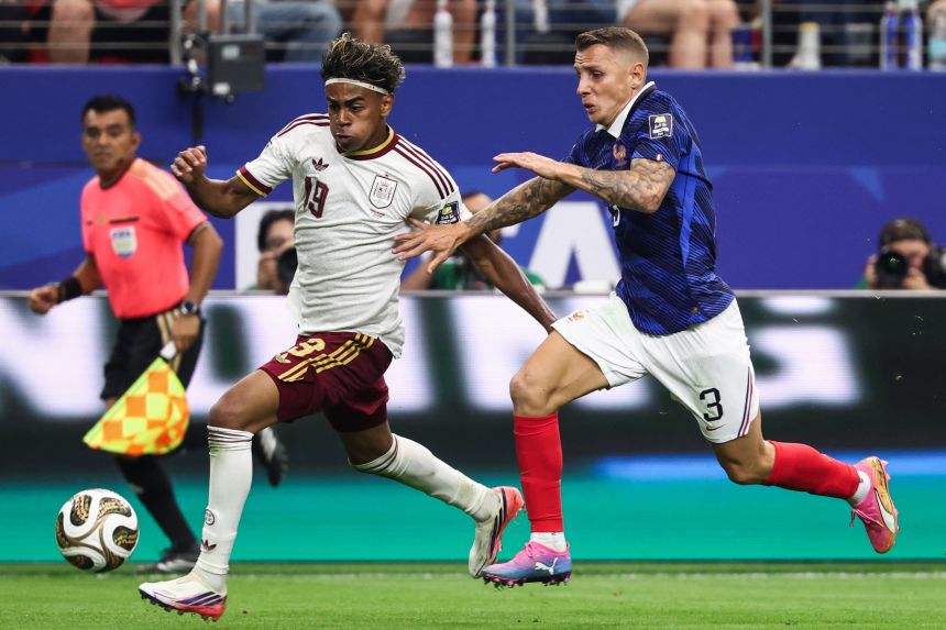 Spain's Lamine Yamal races down the wing with France's Lucas Digne defending.