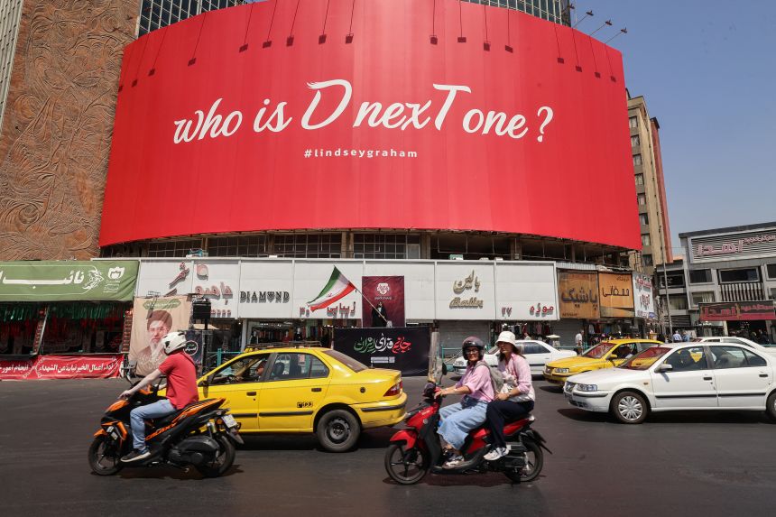 Motorcyclists ride past a huge anti-US billboard referring to the death of US Senator Lindsey Graham at Valiasr Square in Tehran on July 19. The United States said airstrikes on July 19 aimed to