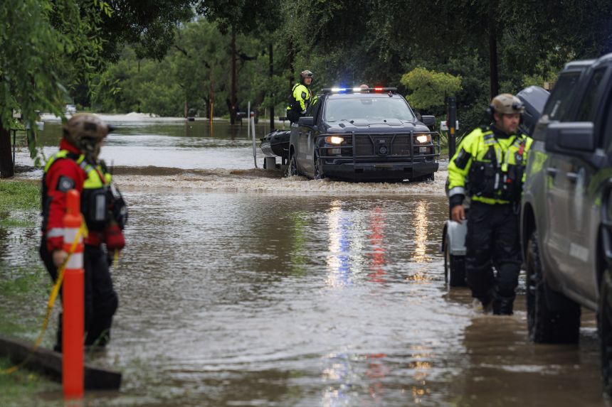 First responders with the Texas Game Wardens travel up East Mesquite Street in Uvalde on Thursday after performing a water rescue as the Leona River flooded the roadway.