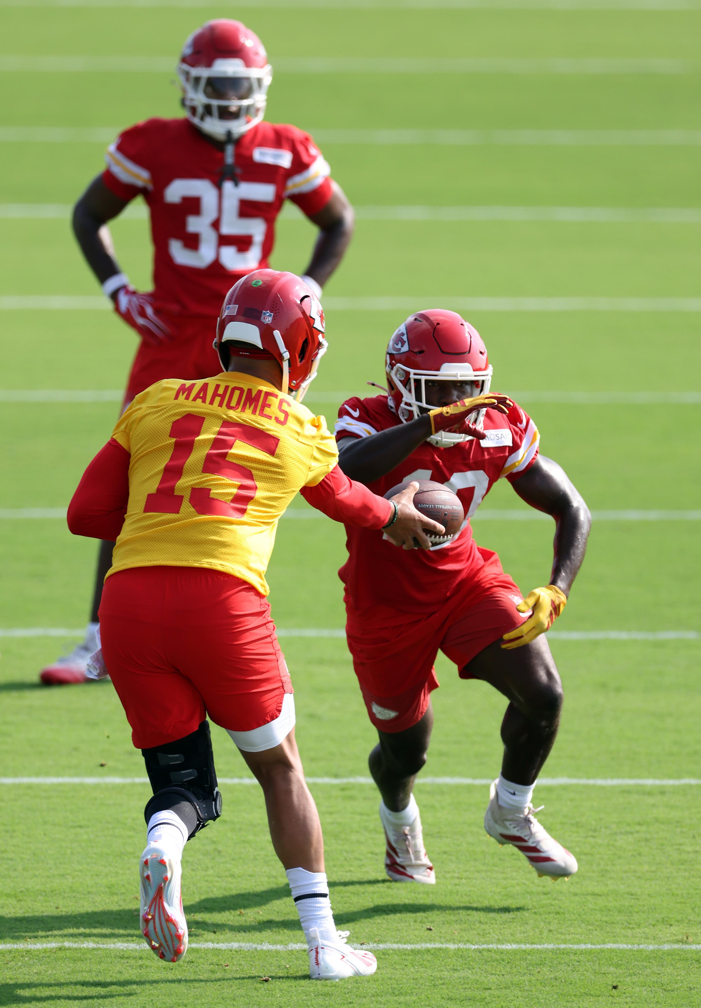 ST JOSEPH, MISSOURI - JULY 25: Quarterback Patrick Mahomes #15 hands off to Emmett Johnson #10 during Kansas City Chiefs Training Camp at Missouri Western State University on July 25, 2026 in St Joseph, Missouri. (Photo by Jamie Squire/Getty Images)