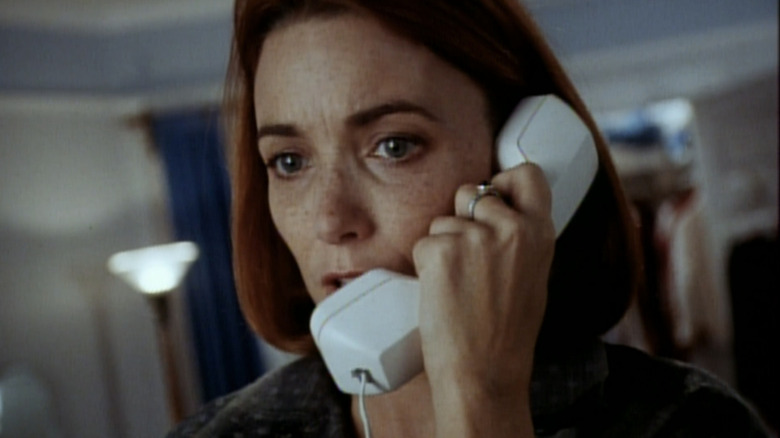 Karen Allen's Terry Munroe looks worried as she talks on. a phone in Ghost in the Machine