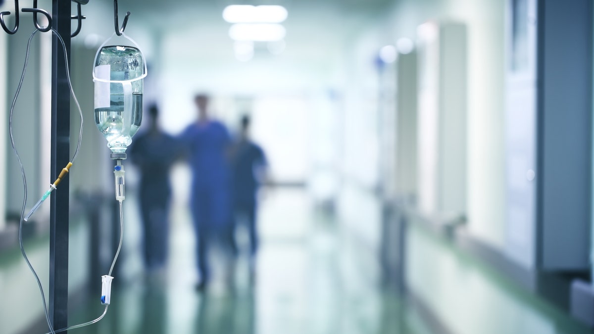 561f89e7-Group of doctors in a hurry down the hospital hallway