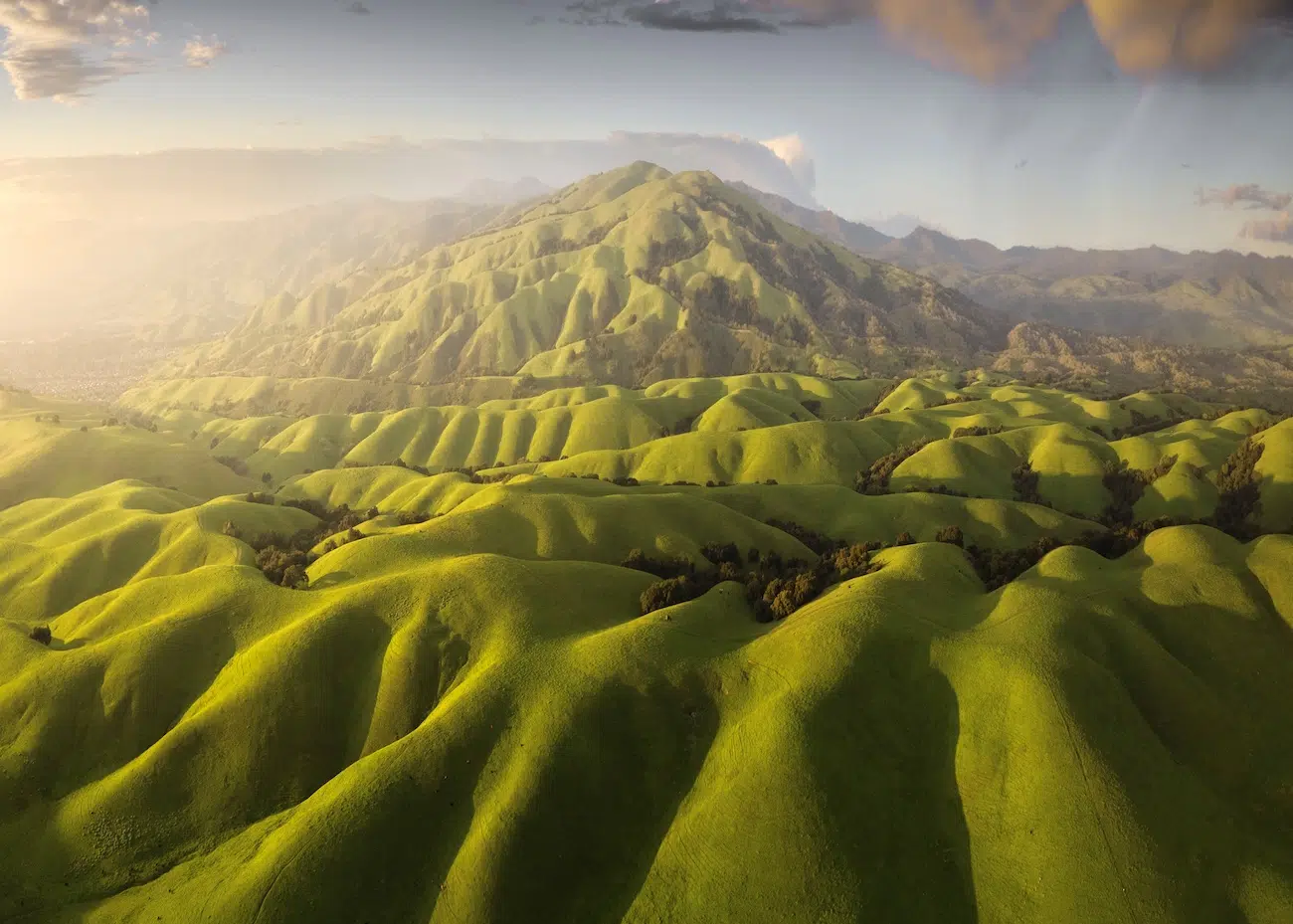 Chengming Liu, United States. Emerald Waves at Dusk. Captured above the rolling hills of San Jose, California at golden hour, this image reveals the Diablo Range at its greenest after winter rains, highlighting smooth contours and flowing patterns. 