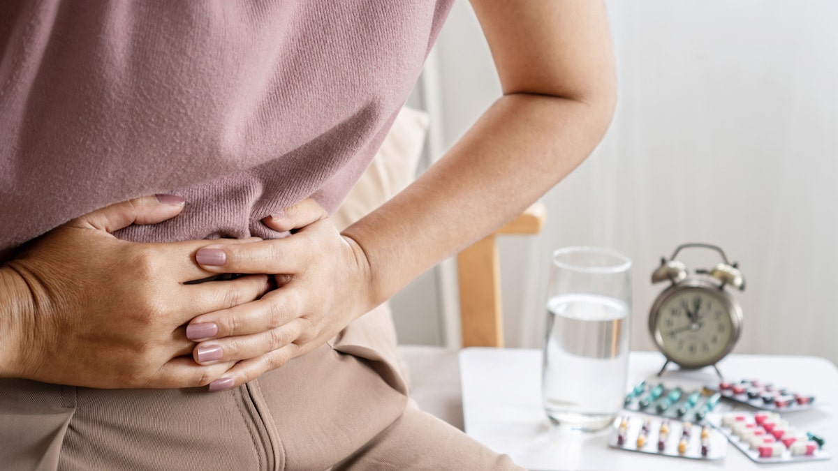 Person clutching theit stomach, apparently in pain.