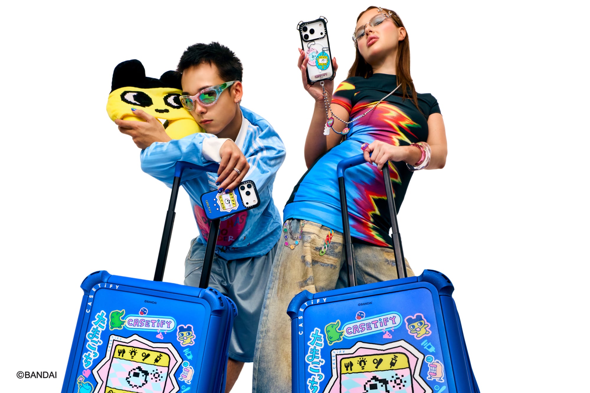 Two people each holding the handle of a 21-inch carry-on suitcase.