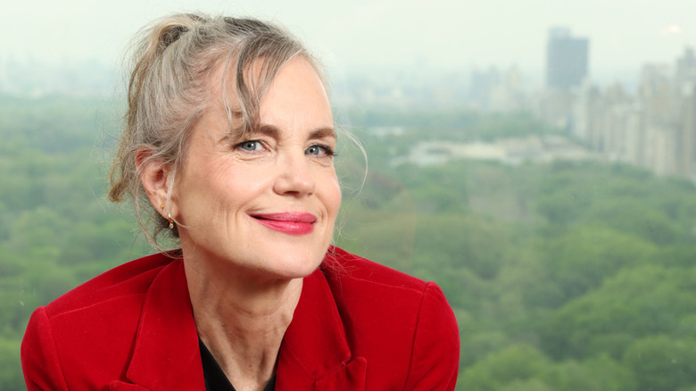 Elizabeth McGovern in a red blazer sitting in front of a view of Central Park