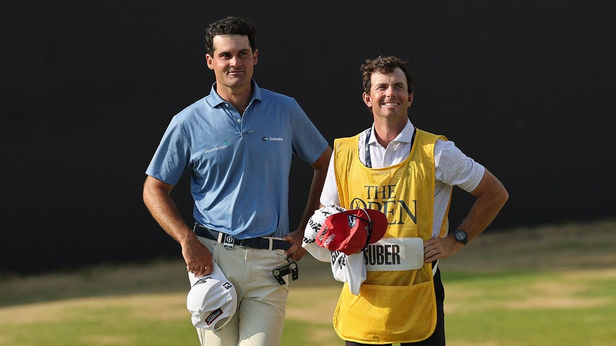 Jackson Suber smiles with caddie Greyson Porter on the 18th green.