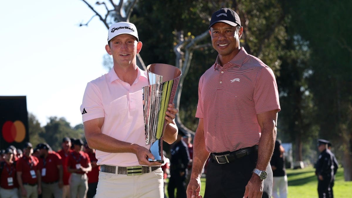 Jacob Bridgeman poses with the trophy and Tiger Woods after winning The 2026 Genesis Invitational at Riviera Country Club.