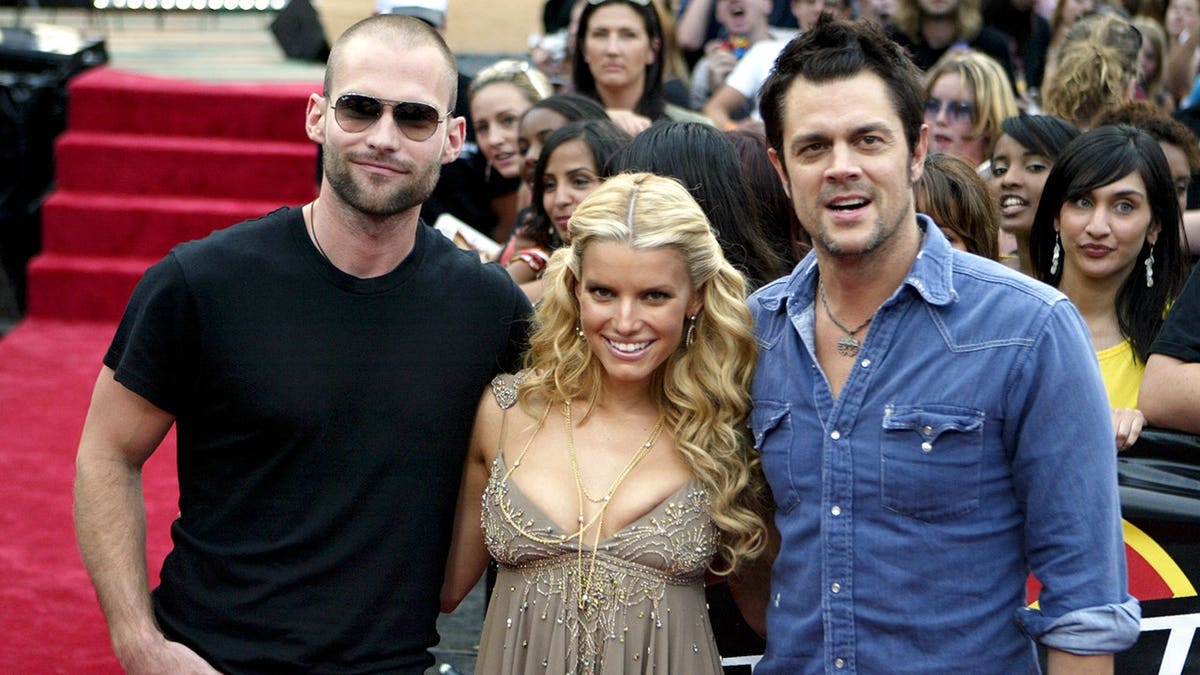 Sean William Scott, Jessica Simpson and Johnny Knoxville pose together during a television appearance.