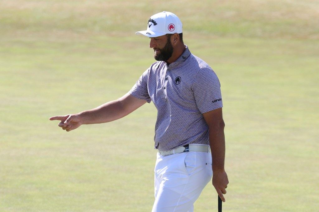 Golfer Jon Rahm pointing on the course.