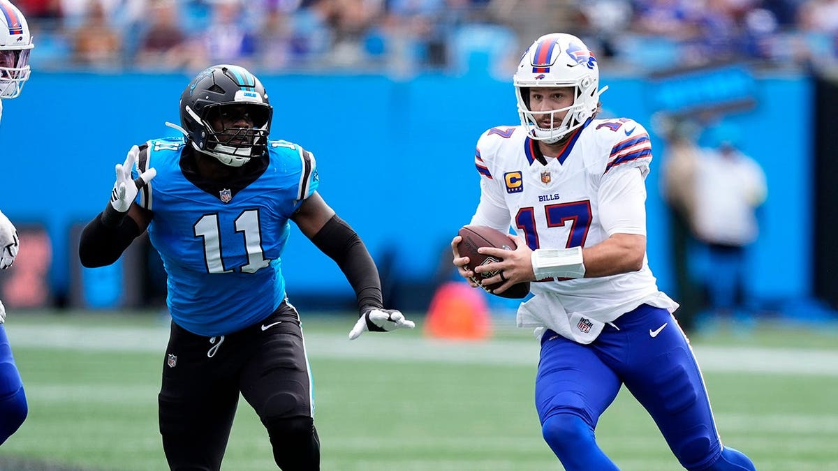 Josh Allen scrambles as Nic Scourton pursues during an NFL game.