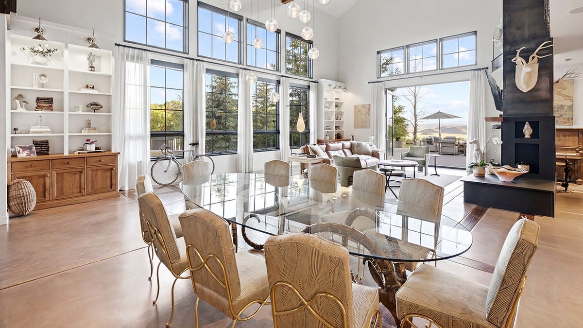 A dining room with a clear table in an open floorplan home.