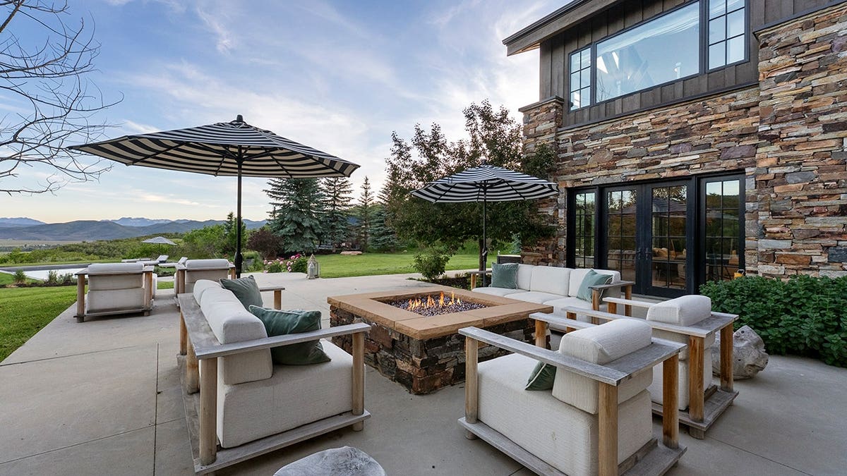 A fire pit outside a home lined with stone.