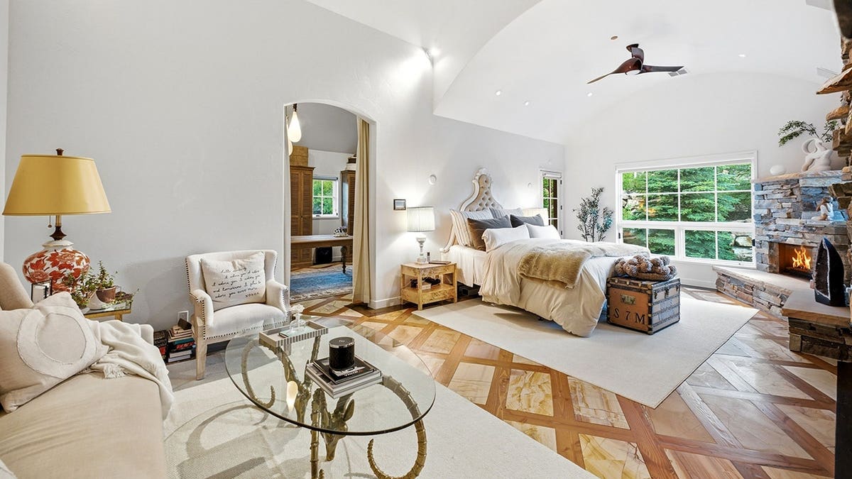 A large bedroom with a sitting area and a fireplace.