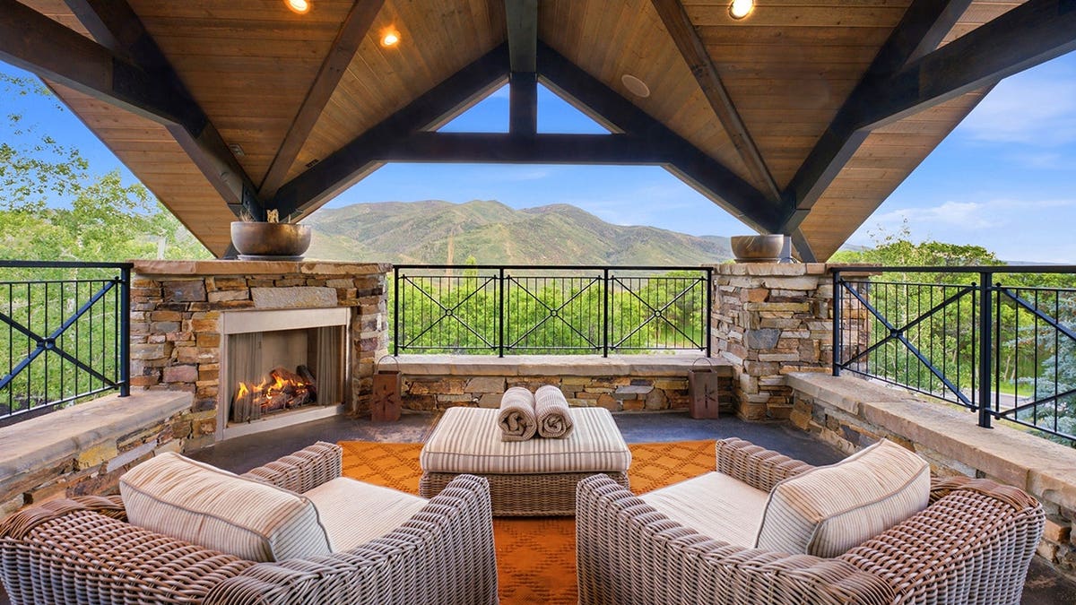 A outdoor terrace with couches and an orange carpet.
