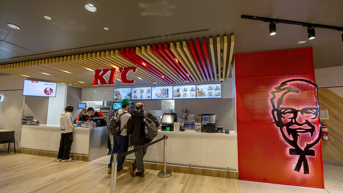 People stand in line at a KFC restaurant.