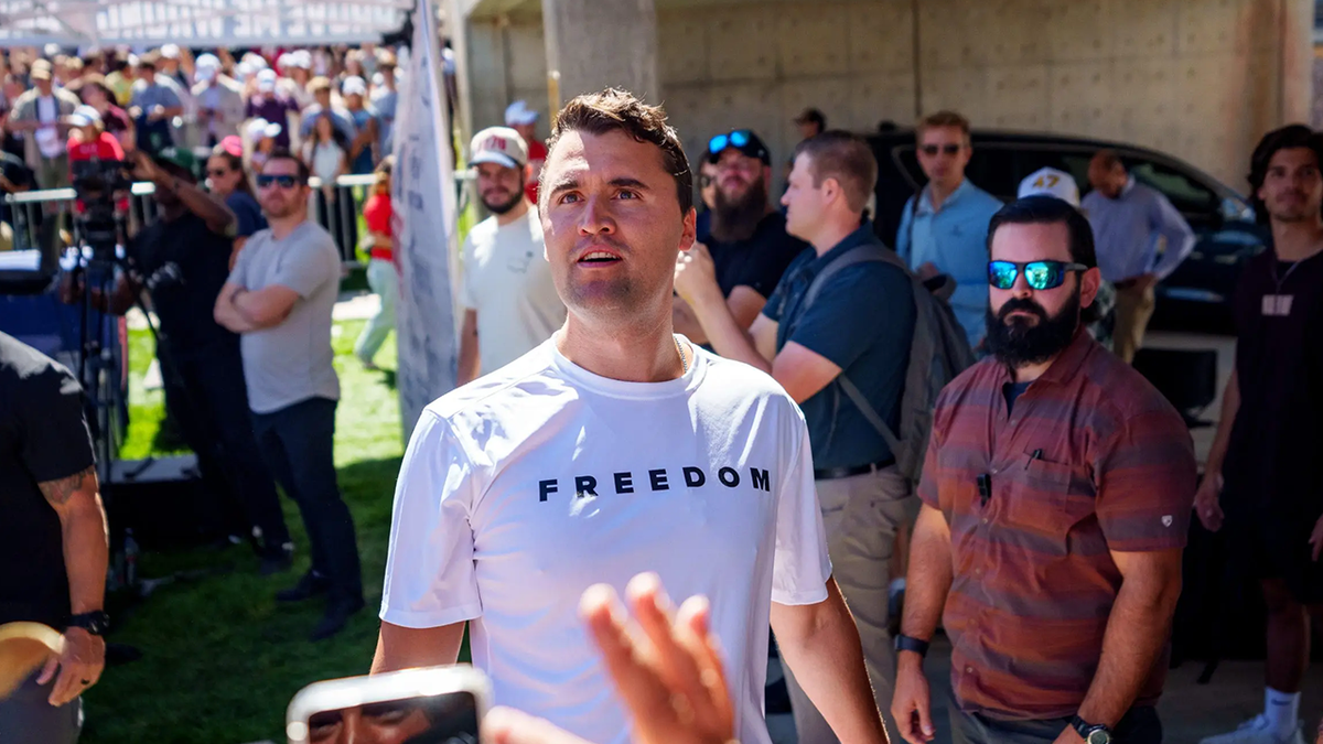 Charlie Kirk in a white T-shirt emblazoned with the word 