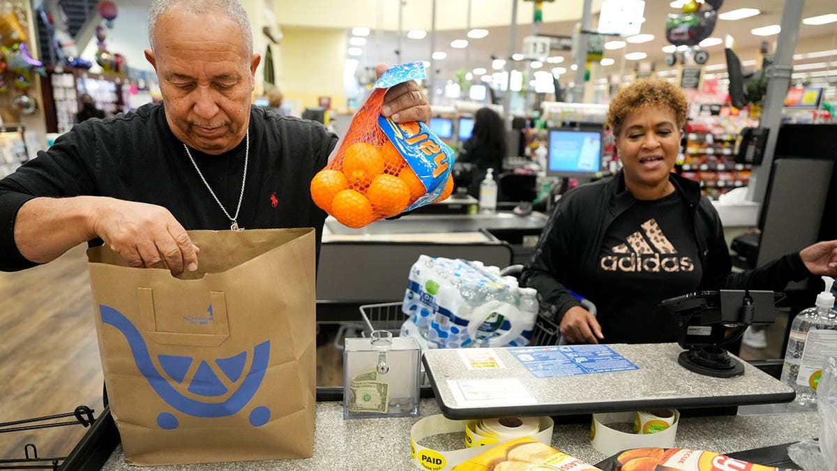 Some people pay for groceries at a Kroger store.