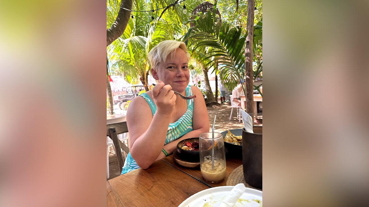 Liz Waddell smiling while eating