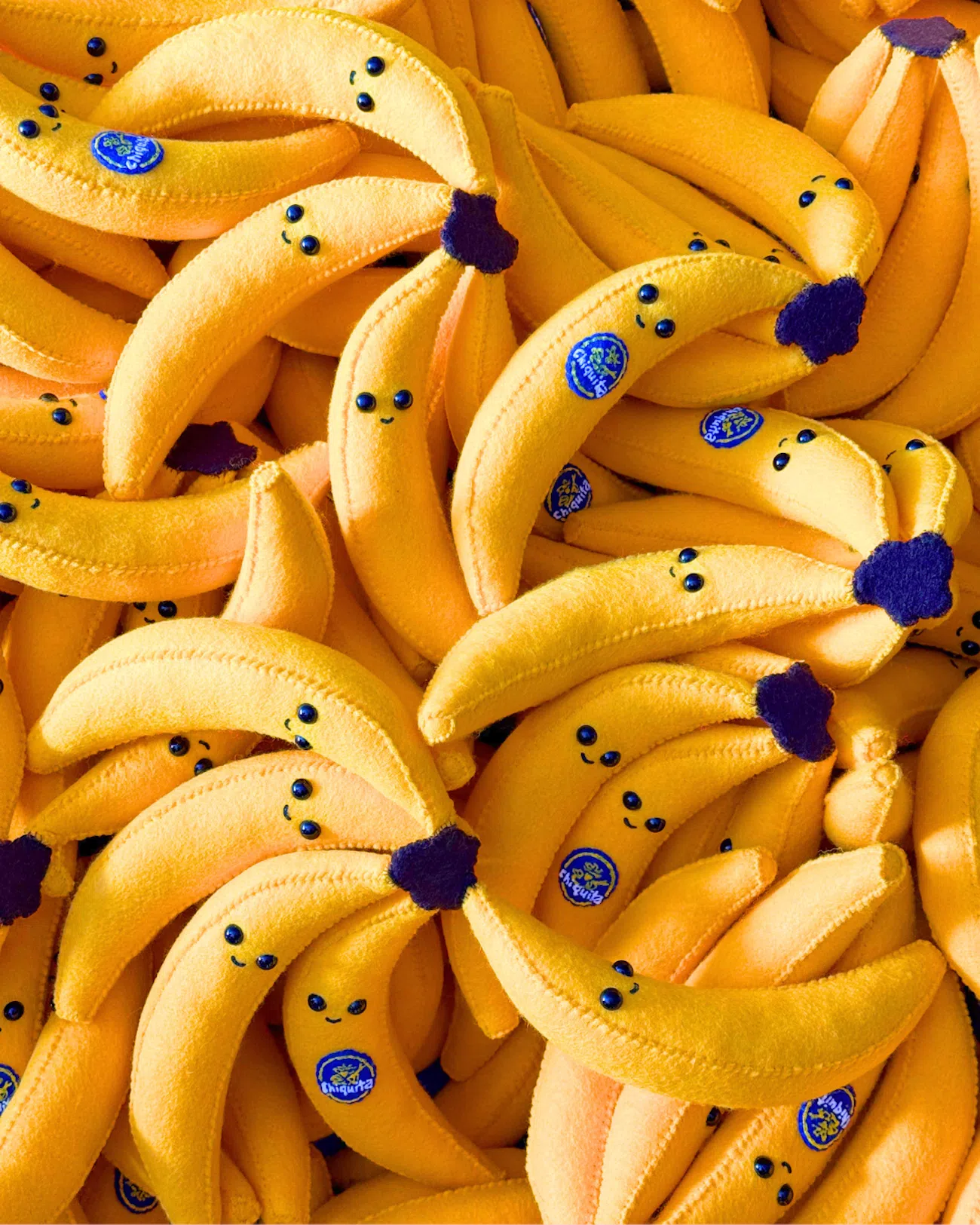 Bananas with little faces reimagined in felt by artist Lucy Sparrow