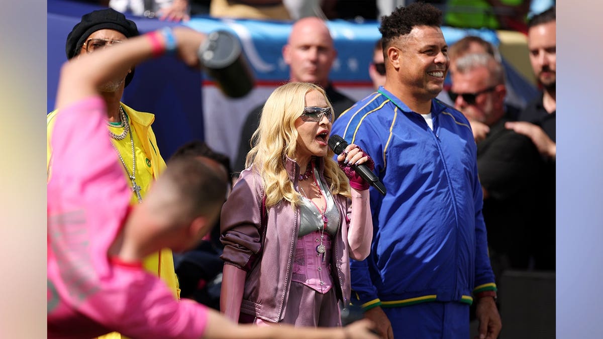 Ronaldinho, Madonna and Ronaldo perform on a stage during a halftime show.