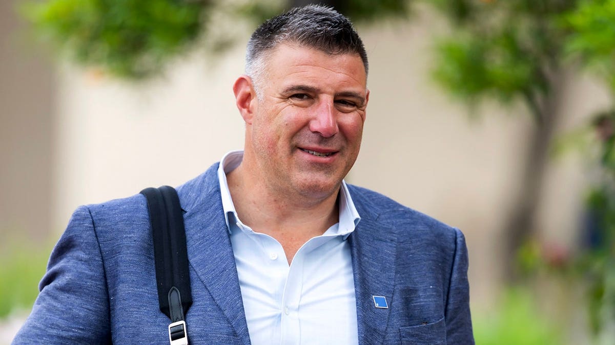 New England Patriots head coach Mike Vrabel standing at a podium during NFL meeting