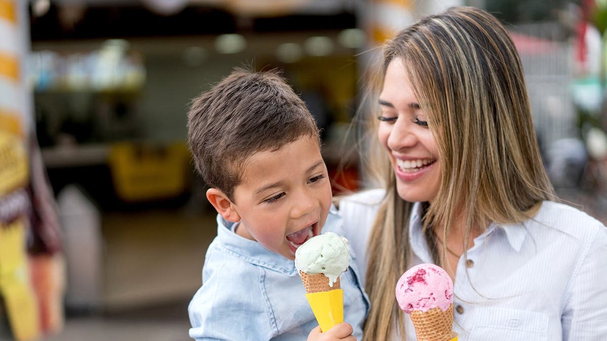 A mother and son enjoy ice-cream cones.