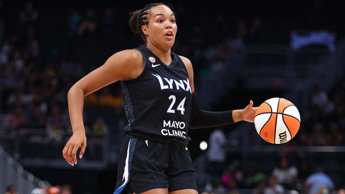 Napheesa Collier dribbles the ball during a Minnesota Lynx game against the Seattle Storm.