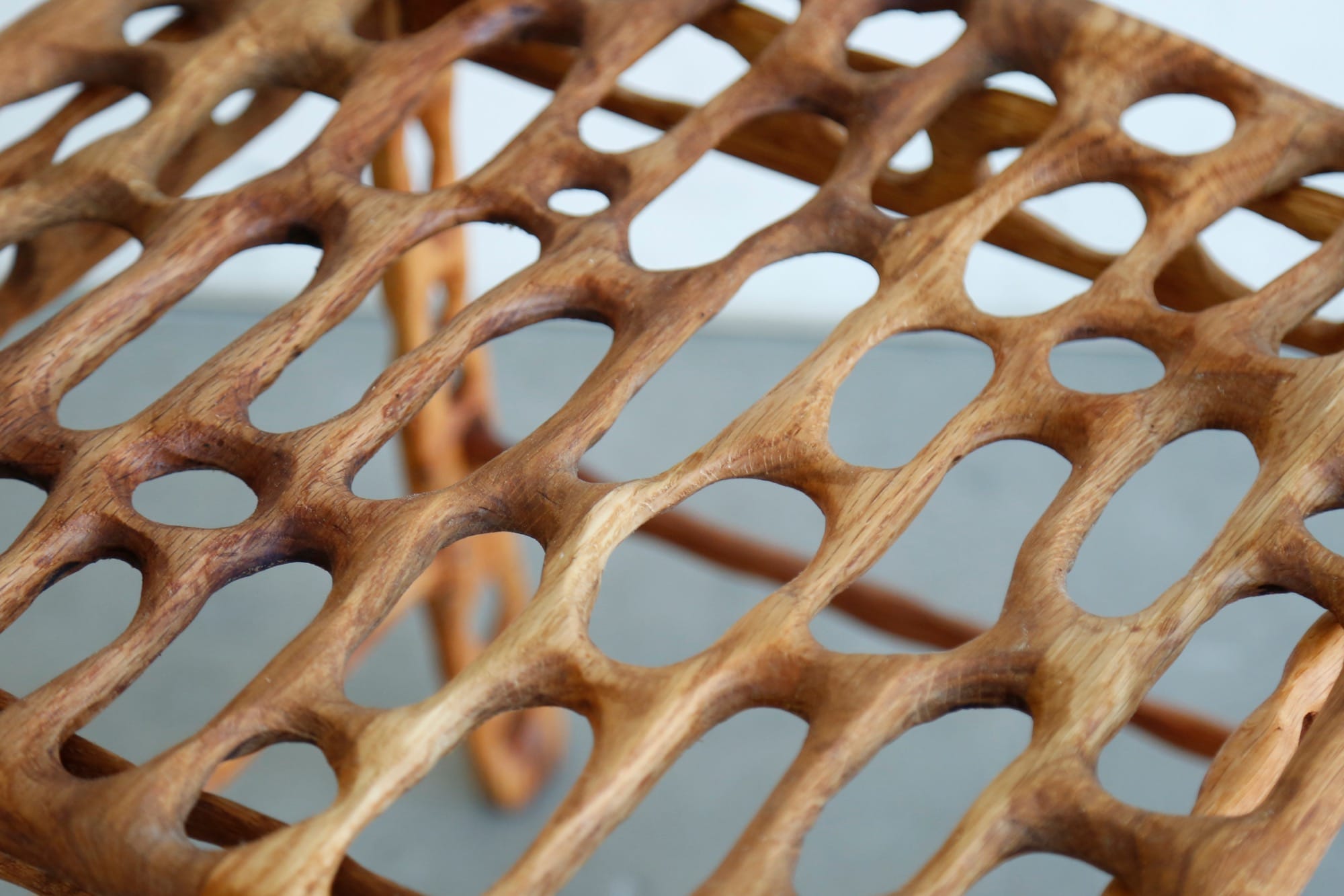 a detail image of a carved wood furniture piece with irregularly shaped holes