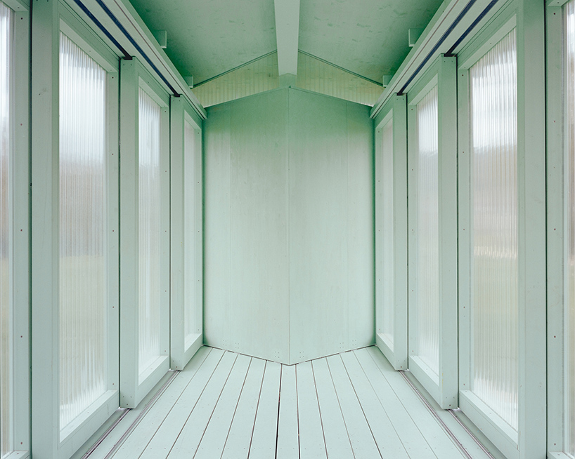 sliding timber frames and reused materials shape reversible pavilion within swiss meadow - 7