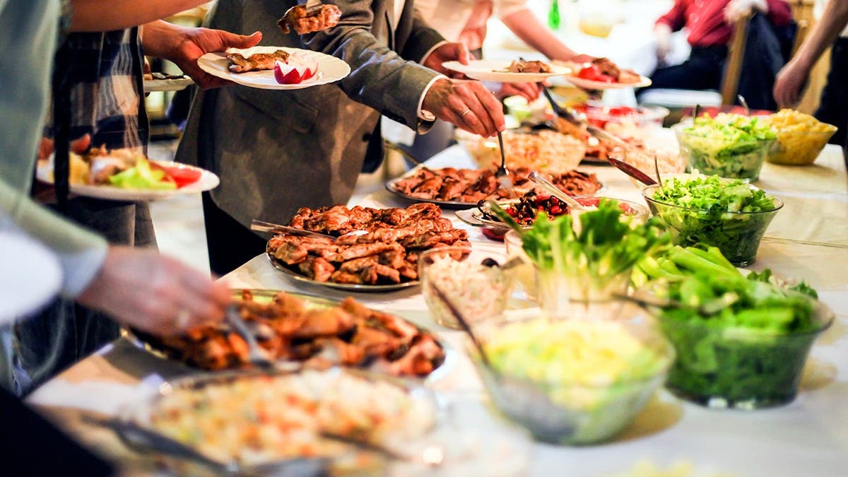 People help themselves to a buffet spread.