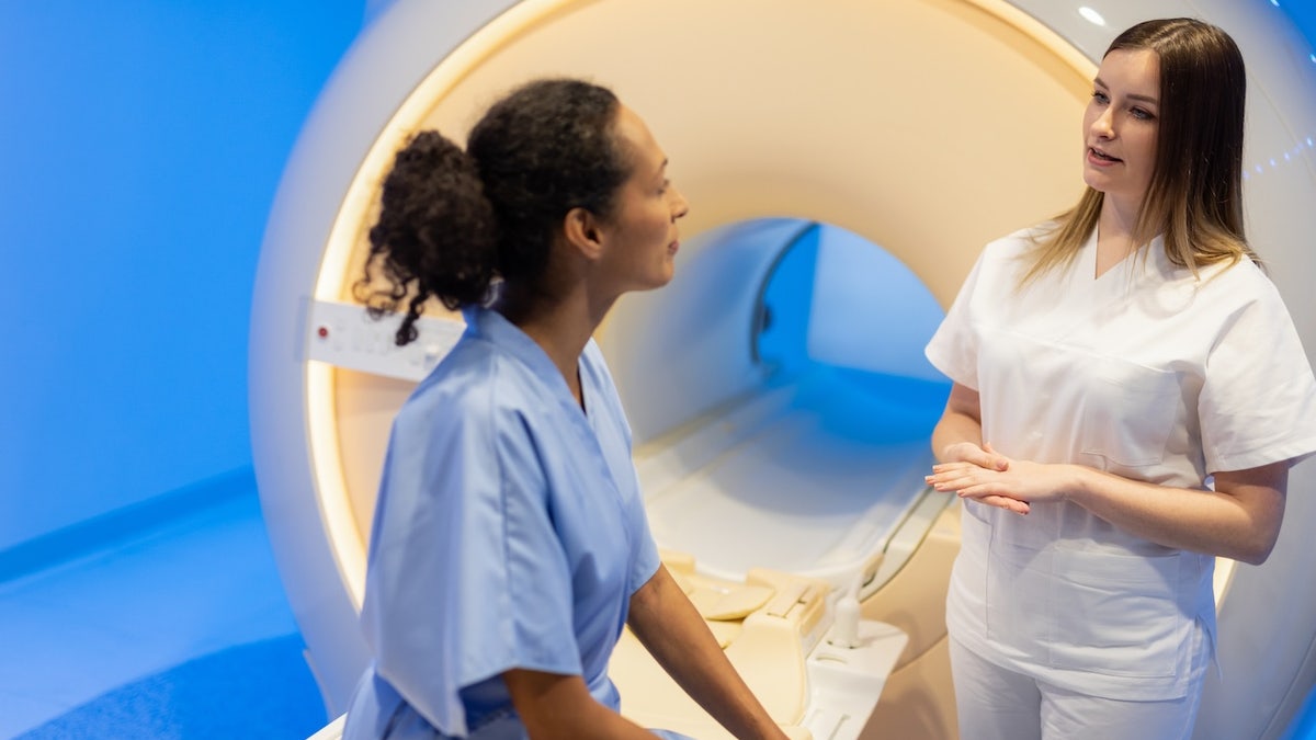 Woman discussing MRI with technician