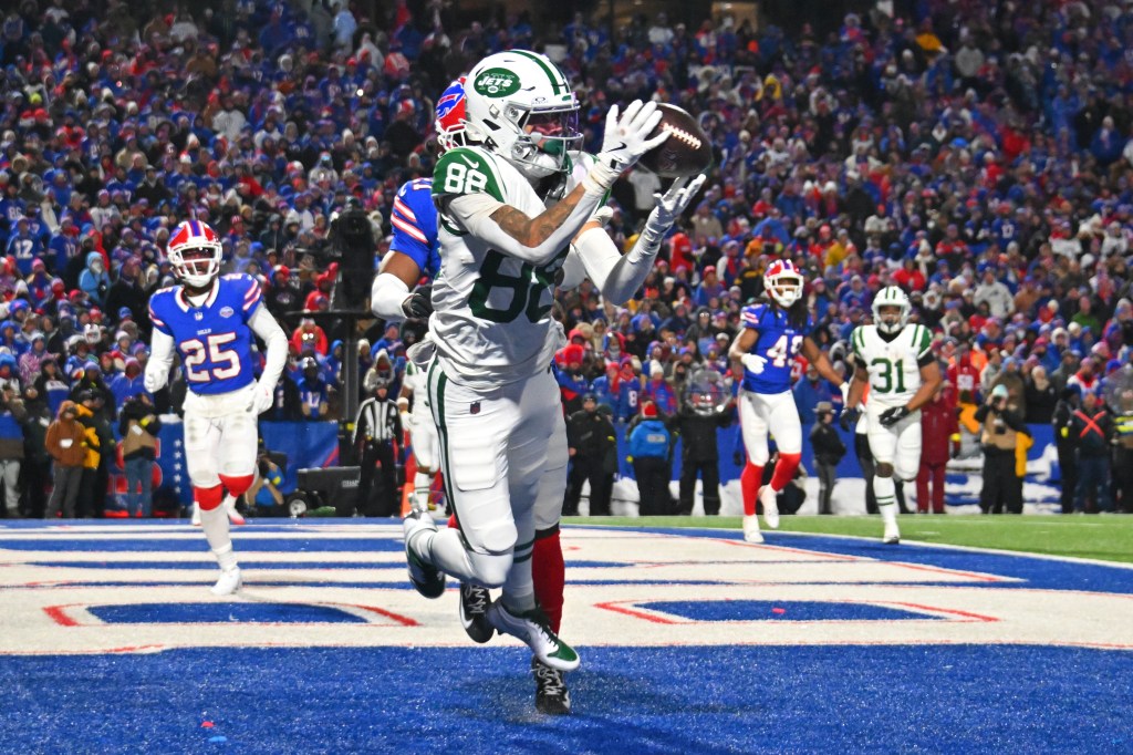 A New York Jets player catches a football in the endzone during an NFL game against the Buffalo Bills.