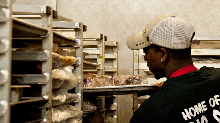 workers places food in freezer racks