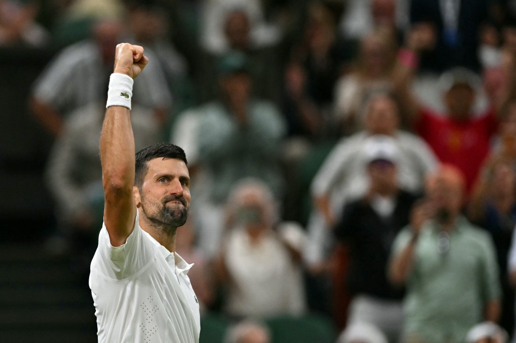 Novak Djokovic raising his arm in celebration during a tennis match.