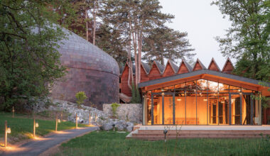 copper shingles wrap curving concert hall in évian, france