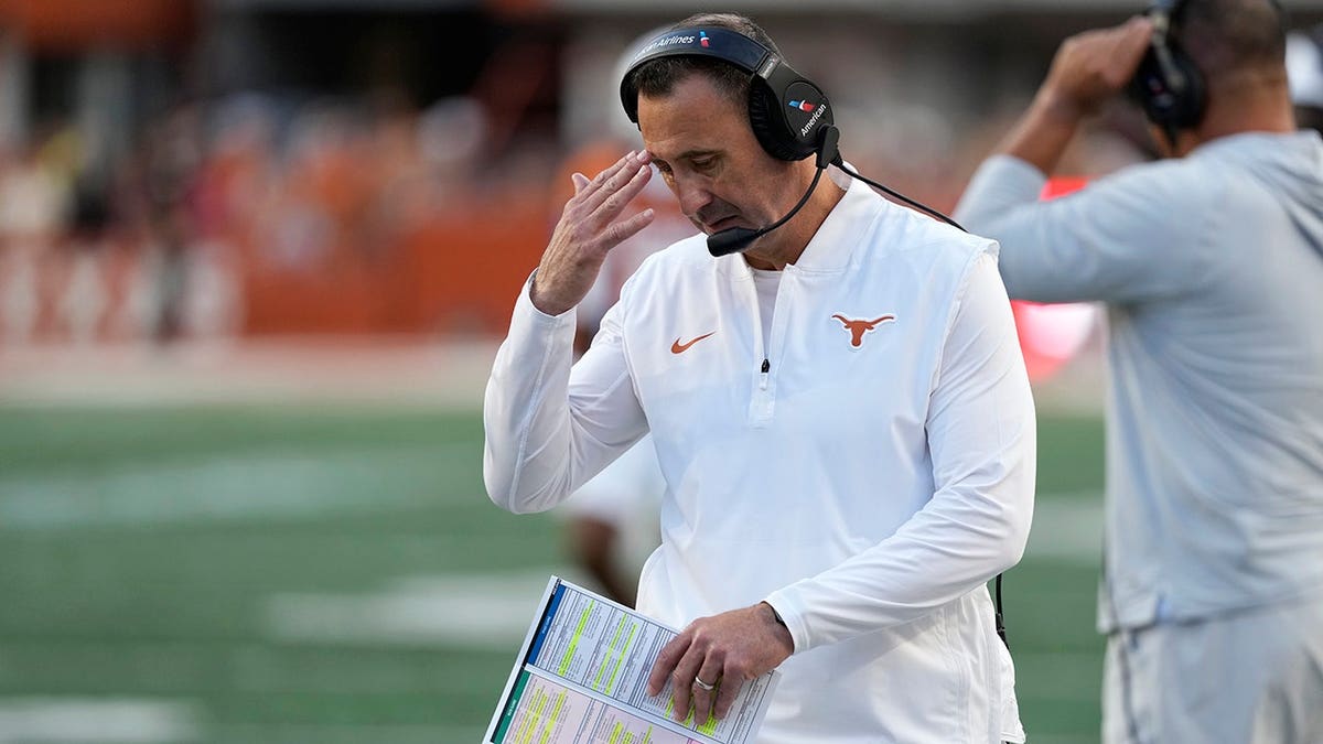 Texas Longhorns head coach Steve Sarkisian pausing on the sidelines during a football game.