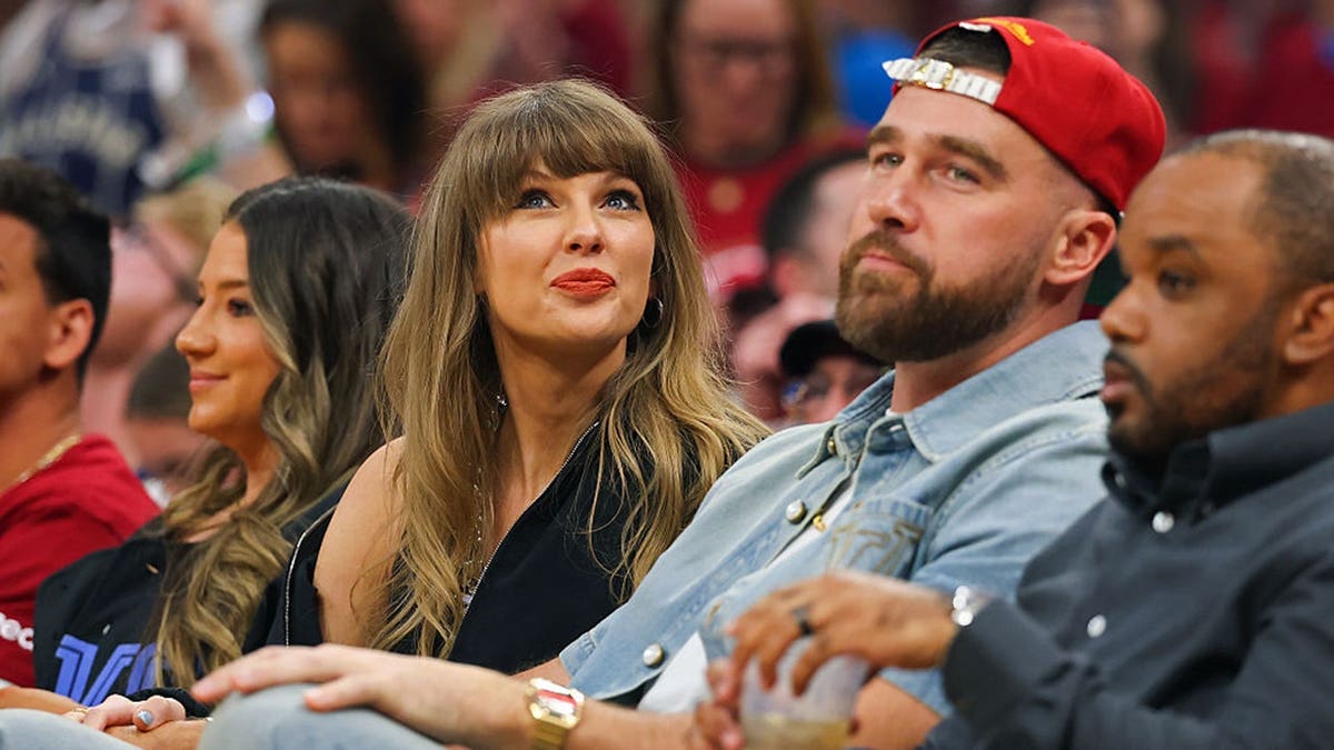 Taylor Swift and Travis Kelce seated at Rocket Arena during NBA Eastern Conference Finals game.