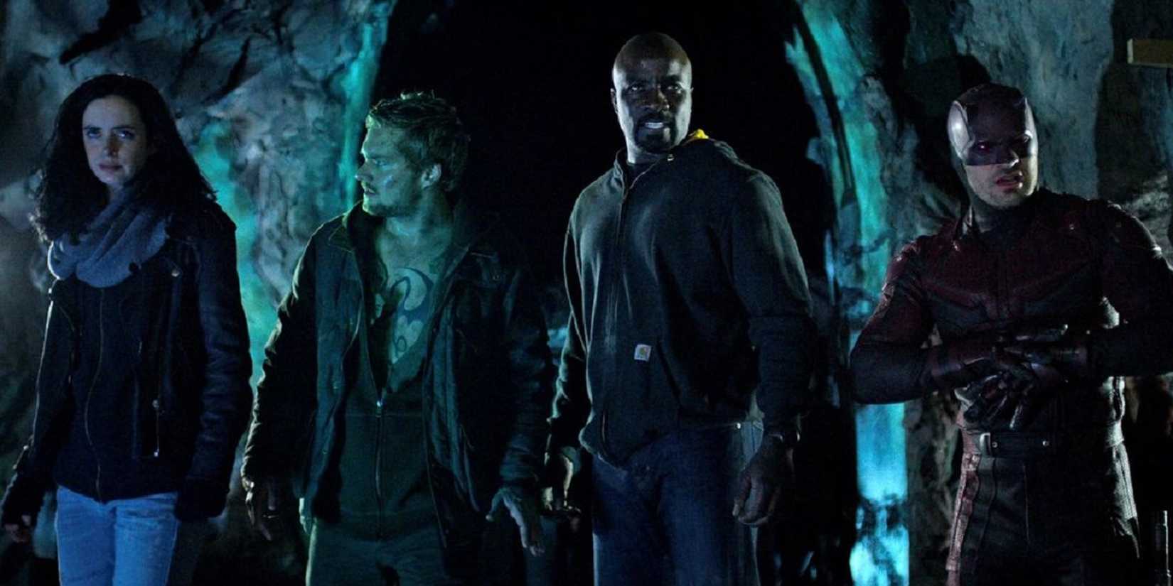 The Defenders standing in line in a dark space