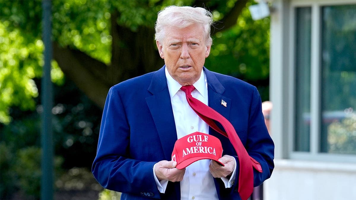 Trump holds a hat