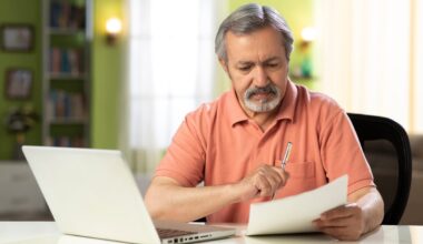 Serious person holding pen and looking at note.