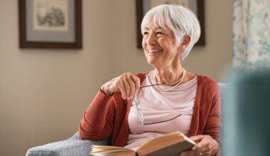 A smiling person holding a book.