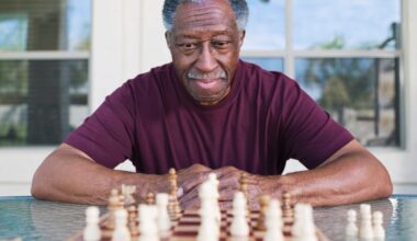 A person sitting in front of a chess board contemplating game strategy.