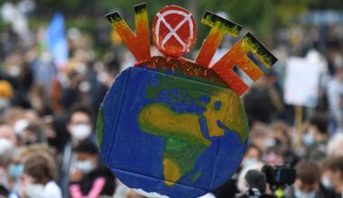 A protester holds up an Earth-shaped sign reading “Vote.”