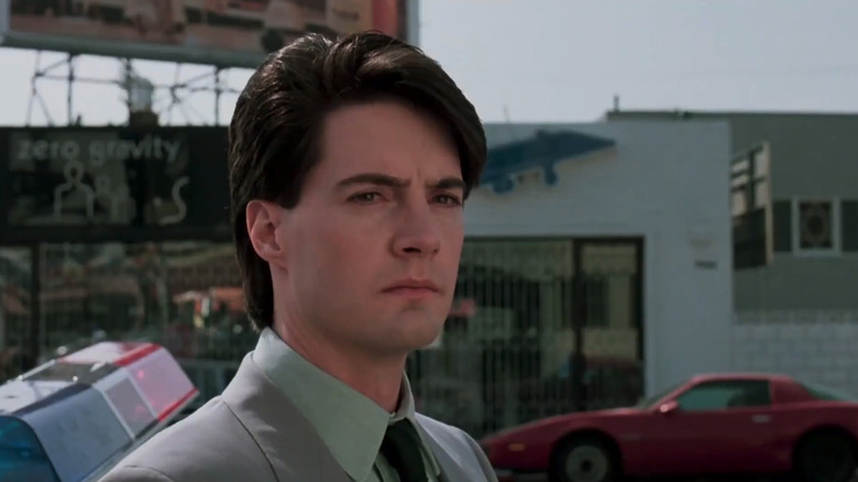 Kyle MacLachlan's Special Agent Lloyd Gallagher looks across frame as he stands on a city street in The Hidden