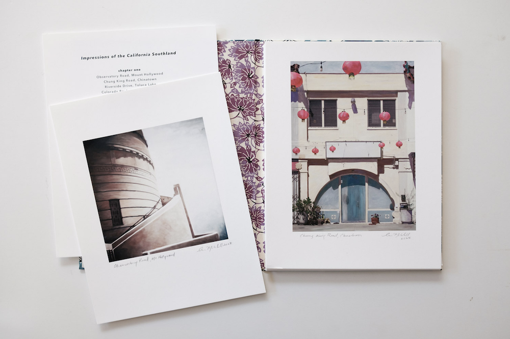 Loose artist-book pages with photographs and text arranged on a white surface, © Ann Mitchell.
