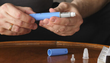 A man holds an injector for a weight-loss drug.